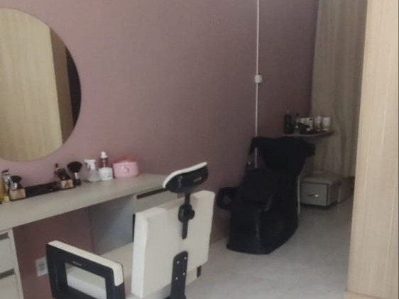 Sala de atendimento do Espaço Anny Teixeira com espelho redondo